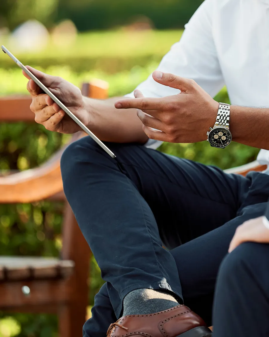 Two people in business dress discussing a proposal on a tablet